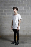 Side angle view of Basic Raw-Cut Elongated Short Sleeve Tee in Off-White on model