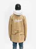 Embroidered Profound logo. Back view of Elongated Cold War Work Jacket in Camel 