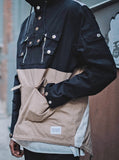 Candid shot of Fishtail Two-Tone Cargo Pocket Pullover in Black/Khaki showcasing silver hardware details and front pocket