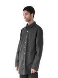 Side angle view of Elongated Button Down Canvas Shirt in Black on model