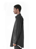 Left side view of Elongated Button Down Canvas Shirt in Black on model