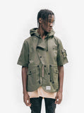 Jacket closed, front view of Short-Sleeve Asymmetrical Hooded Parka in Olive on model