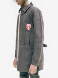 Left side detail of Elongated Cold War Work Jacket in Black featuring red contrasting patchwork