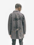 Back view image of Elongated Cold War Work Jacket in Black on model, featuring embroidered script logo