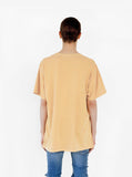 Back view of Pigment Dyed Basic Tee in Burnt Banana on model with blue denim.