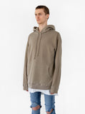 Side angle view of model wearing Pigment Dyed Washed Hoodie in Faded Khaki 